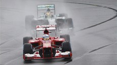 Fernando Alonso s vozem Ferrari před Lewisem Hamiltonem na Mercedesu v