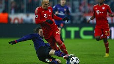 eský záloník Tomá Rosický z Arsenalu fauluje Arjena Robbena z Bayernu v