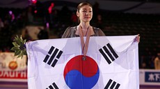 Kim Ju-na pózuje po svém triumfu s jihokorejskiu vlajkou.