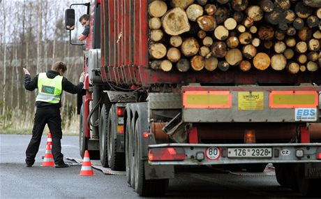 Policisté pevaují kamiony a nákladní vozy pi kontrolní akci.