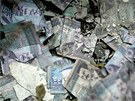 Hromady roztrhaných a popálených bankovek s portrétem Saddáma Husajna, které...