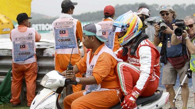 Fernando Alonso opout pi Velk cen Malajsie okruh v Sepangu na motorce jednoho z pomocnk na trati. 