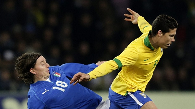 Italsk fotbalista Riccardo Montolivo (vlevo) se pokou vypchnout m Brazilci Hernanesovi.