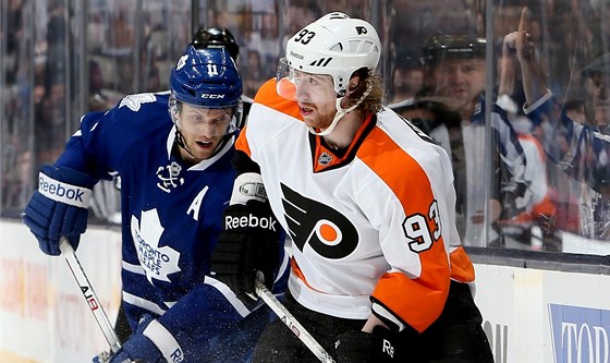 Jakub Voráek (vpravo) z Philadelphie v souboji s Jayem McClementem z Toronta. 