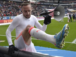 JDE SE ZA FANOUKY. Ribéry pelézá reklamní panel, aby si ho fanouci mohli...