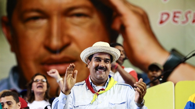 Nicolas Maduro bhem setkn se svmi pznivci. V pozad portrt Huga Chveze (27. bezna 2013)