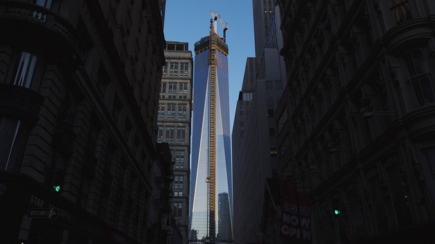Paprsky vychzejccho slunce prv dopadaj na prosklenou fasdu newyorskho mrakodrapu One World Trade Center.
