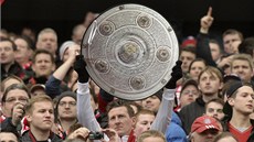 TENHLE CHCEME. Fanoušek Bayernu třímá repliku mistrovské trofeje.