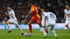 TANK. Didier Drogba z Galatasaraye se probíjí p�es hrá�e Realu Madrid.