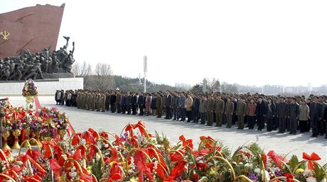 Zástup lidí stojí u památníku vného prezidenta Kim Ir-sena. 
