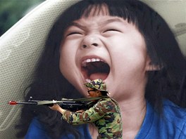 KONTRAST. Jihokorejský voják drí svou zbra ped portrétem kiící holiky na...