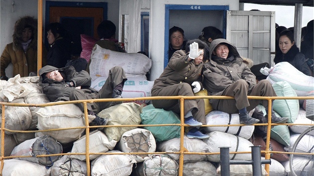 Severokorejci na lodi plujc po ece Yalu, kter tvo hranici s nou (11. bezna 2013)