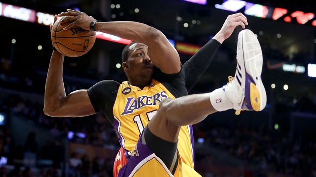 Dwight Howard z Los Angeles Lakers ve výskoku postrený jedním z hrá
