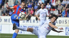 Daniel Kolá� z Plzn� (vlevo) zpracovává mí� v obtí�né pozici. Tvrdým skluzem ho