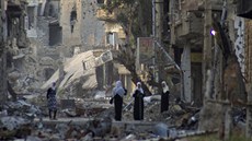 Lidé stojí v ulicích zničeného syrského města Dajr az-Zaur.