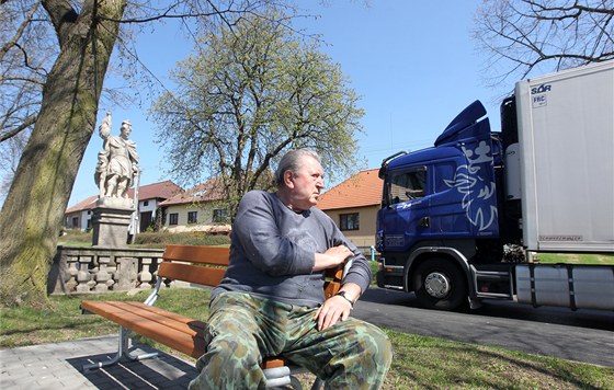 Jií Hrza v Heralticích na návsi pozoruje jeden projídjící kamion za druhým.