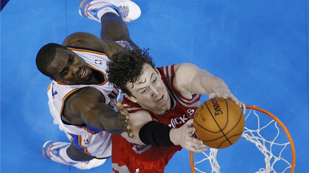 Omer Asik  z Houstonu smeuje, lep se na nj Serge Ibaka z tmu Oklahoma City.