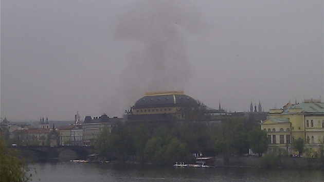 Nad budovou Národního divadla stoupá hustý erný dým.