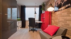 Pracovna po prom�n�: designé�i vsadili na industriální styl o�ivený �ervenou.