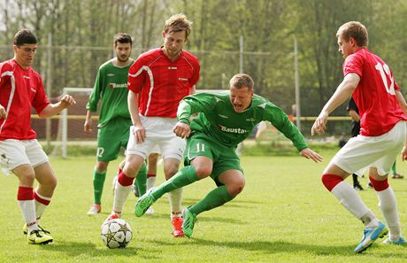 Martin Bedná padá po faulu k zemi, 1.FC Karlovy Vary (v zeleném) hostily