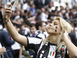JAK MI TO SLUÍ? Fanynka Juventusu se fotí bhem oslav pímo na hiti.