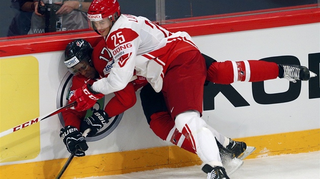 BYL TO BOJ. Hokejist Dnska potrpili Kanadu, tady Oliver Lauridsen tla na mantinel Simmondse.