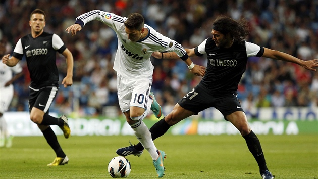Mesut zil (v blm) z Realu Madrid se sna odpoutat od Sergia Sancheze z Malagy. 