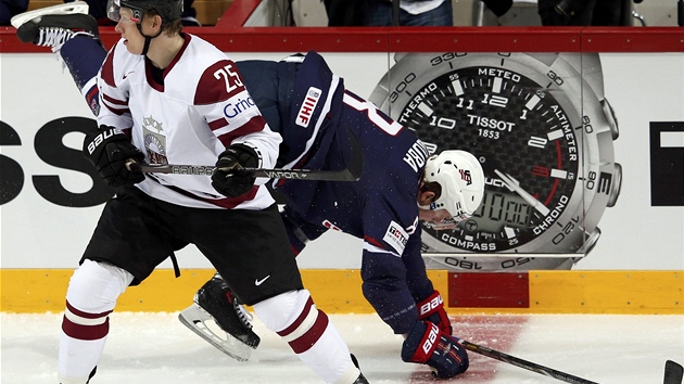 NEUSTÁL TO. Americký hokejista Jacob Trouba padá po souboji s Andrisem Dzerinsem z Lotyšska.