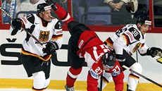 Rakouský hokejista Thomas Hundertpfund (uprosted) padá po souboji s Nmci