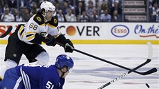 Jaromír Jágr z Bostonu obchází padajícího Jakea Gardinera z Toronta.