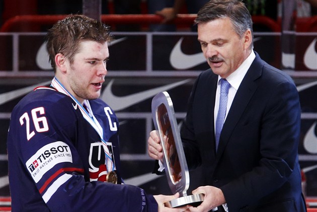 P�EDÁNÍ. Americký kapitán Paul Stastny p�ebírá z rukou Reneho Fasela trofej pro