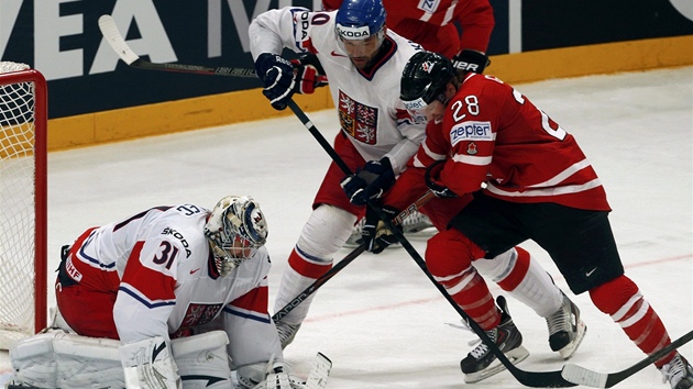 Claude Giroux se dere ped eskou branku. Odblokovat ho chce Zdenk Kutlk, puk u m pod kontrolou brank Ondej Pavelec.