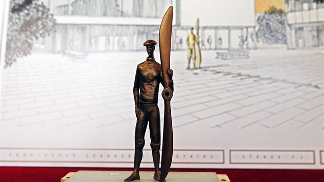 Bronzová figura Jana Kašpara v nadživotní velikosti. V ruce drží vrtuli letadla Blériot, v ploše dlažby se odvíjí svítící osa s daty letcova života.