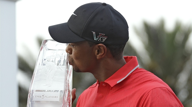 VÍTZNÝ POLIBEK. Tiger Woods s trofejí pro vítze turnaje Players Championship. 