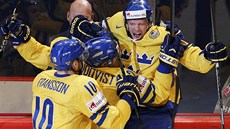 RADOST DOMÁCÍCH. Švédští hokejisté křepčí po gólu do švýcarské branky.