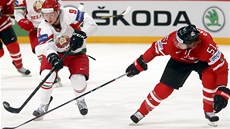 Bloruský hokejista Vjaeslav Andrjuenko (vlevo) se snaí prosadit pes