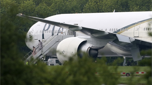 Pasai vystupuj na letiti Stansted z letounu, kter museli kvli ohroen na palub odklonit z Manchesteru (24. kvtna 2013).