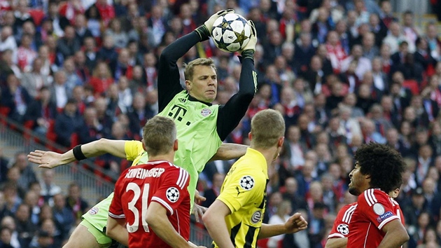 MÁÁÁM! Gólman Bayernu Manuel Neuer vysokočil nejvýš a chytil míč před dotírajícími hráči Dortmundu.