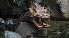 Dřevěná plastika draka shlíží na návštěvníky hřenských soutěsek.