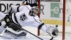 Branká Jonathan Quick z Los Angeles se marn natahuje po puku, který na jeho