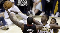 LeBron James (vlevo) z Miami zakonuje akci pes bránícího Roye Hibberta z