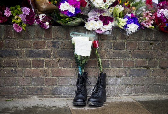 Kvtiny a pár vojenských bot pipomínají památku zavradného briského vojáka v