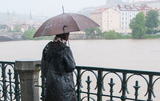 Lidé pozorují bsnící Vltavu.