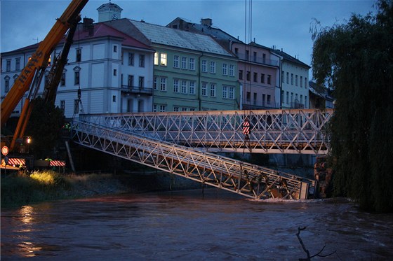 Hasim se nakonec podailo upevnit lávku na obou koncích. elezný most z roku...