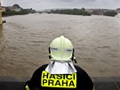 len praského hasiského sboru pozoruje rozvodnnou Vltavu z uzaveného