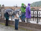 Lidé pozorují bsnící Vltavu.