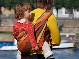 Dítě uvázané v šátku si matka nese jako batoh a rovnoměrně rozkládá jeho váhu...