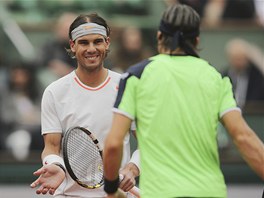 CO JE, KAMARÁDE? panlský tenista Rafael Nadal nad sítí diskutuje s krajanem...