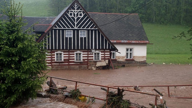 Voda se ene kolem roubenky v Rudnku (erven 2013).