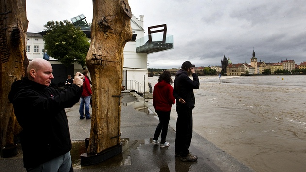 Lidé sledují stoupající Vltavu u Musea Kampa v Praze. Muzeum je kvůli povodňové situaci uzavřeno. (2. června 2013)